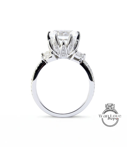 A close-up view of a silver engagement ring with a large central diamond surrounded by smaller diamonds on either side.