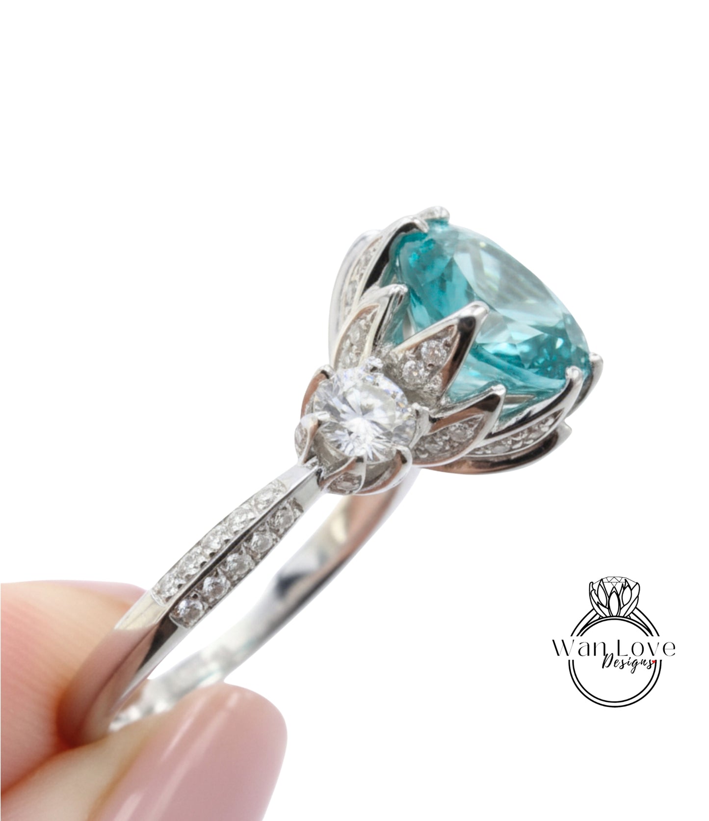 A close-up of a silver ring with a large blue gemstone, possibly a sapphire or aquamarine, surrounded by smaller diamonds.