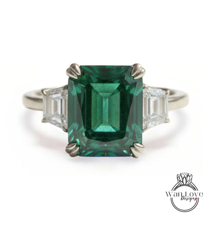 A large, green gemstone ring with a diamond band.