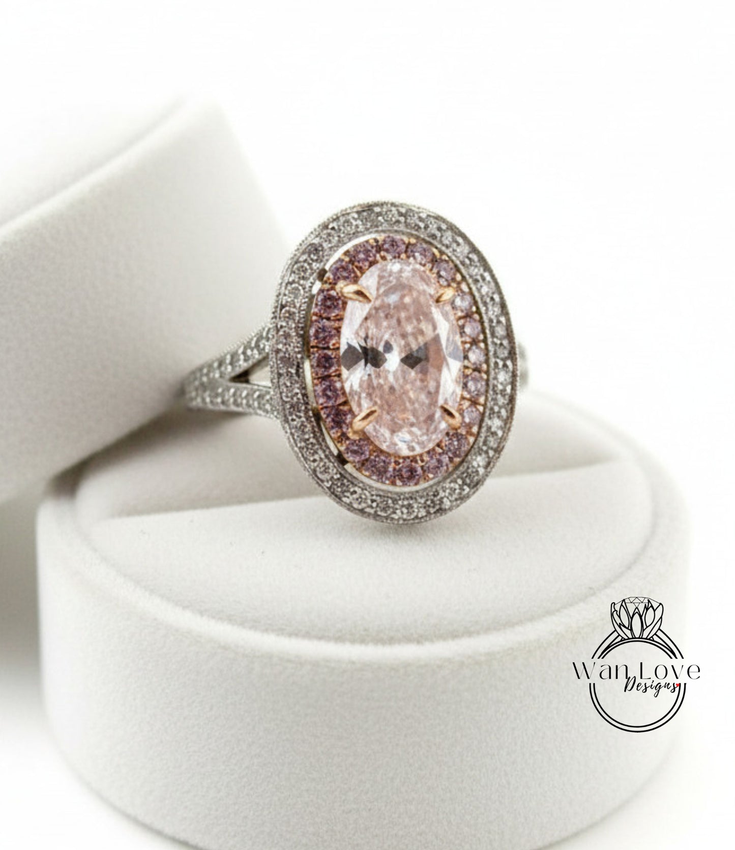 A close-up image of a diamond ring with a large oval-shaped gemstone surrounded by smaller diamonds, placed on a white velvet background.