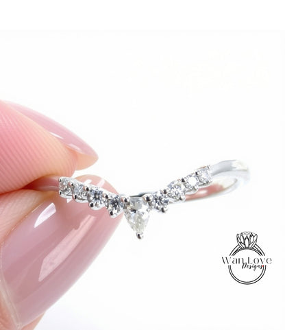 A close-up of a person's hand holding a silver ring with a diamond-encrusted band.