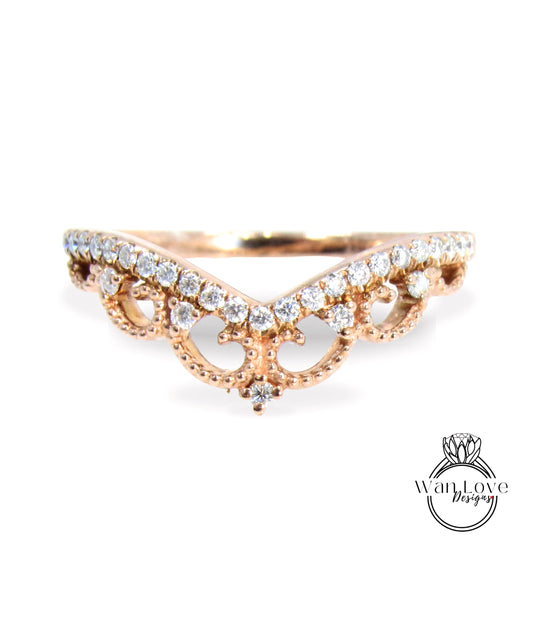 A rose gold ring with a decorative band adorned with small diamonds.