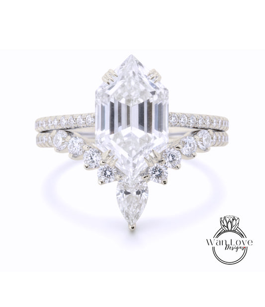A stunning diamond engagement ring with a large, brilliant-cut diamond at the center, surrounded by smaller diamonds and pear-shaped stones. The ring is set in a silver band, and the background is a plain white color.