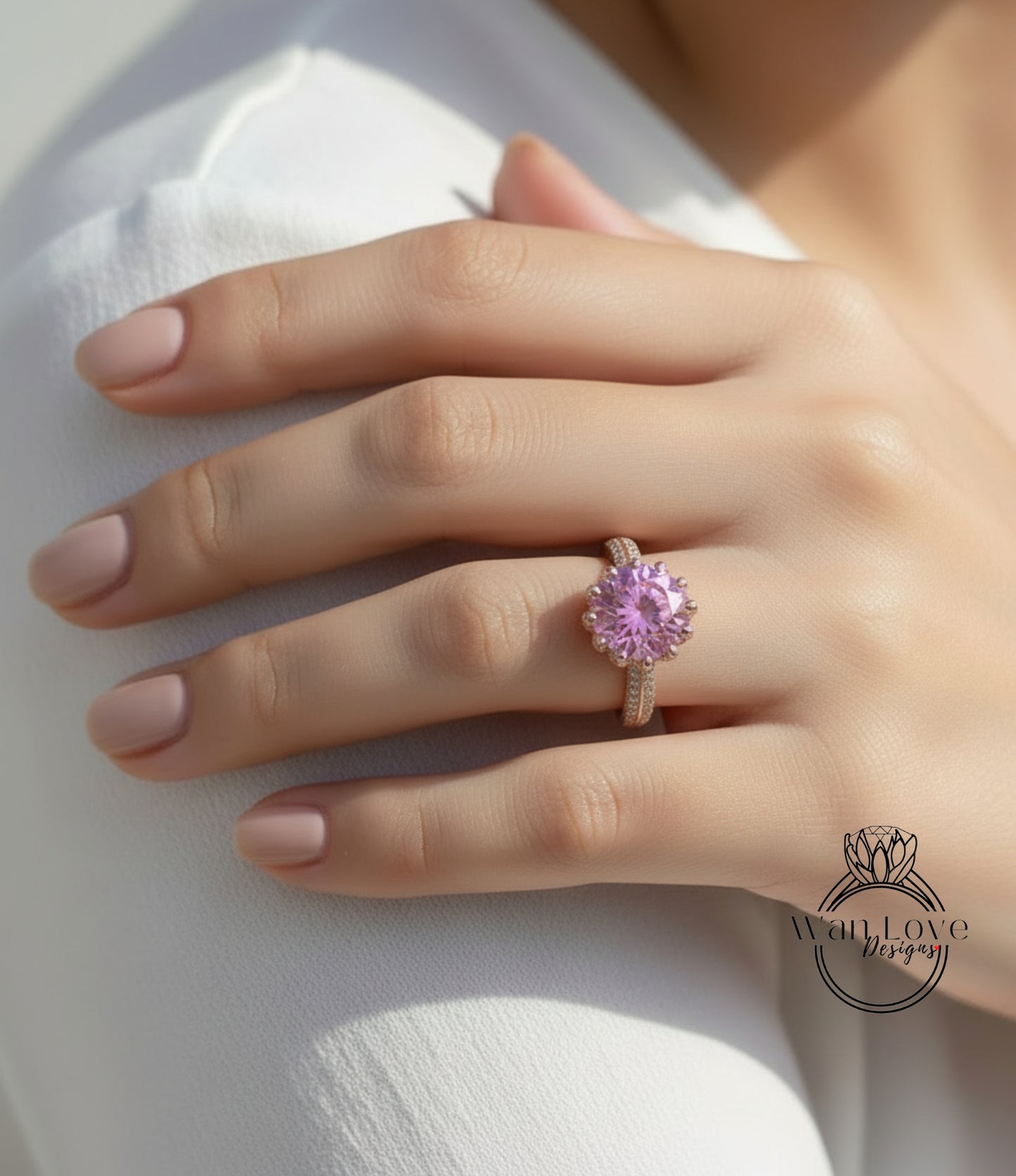 A close-up of a person's hand wearing a pink gemstone ring on the ring finger.