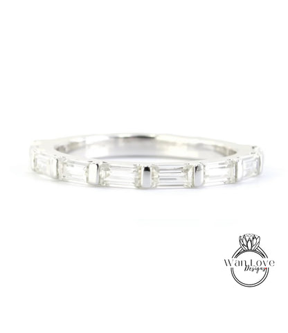 A silver band ring with a row of clear gemstones, likely diamonds, set in a simple and elegant design.