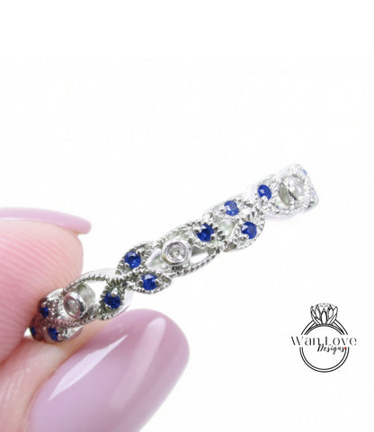 A close-up image of a person's hand holding a silver ring adorned with blue gemstones.