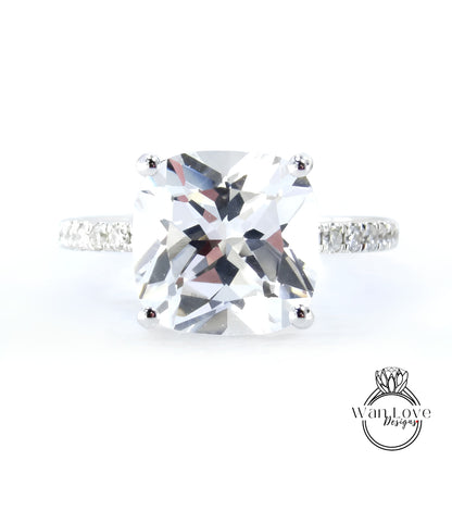 A large, clear gemstone ring with a diamond band, showcasing the intricate details and sparkle of the diamonds.