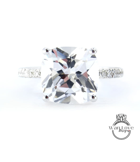 A large, clear gemstone ring with a diamond band, showcasing the intricate details and sparkle of the diamonds.