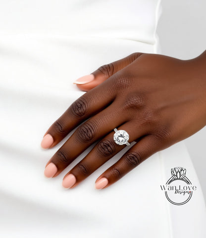 A close-up of a hand wearing a large diamond engagement ring.