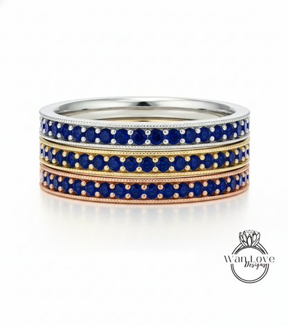 A stack of three rings with blue gemstones set in a metallic band.