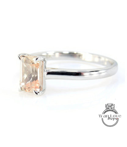 A silver engagement ring with a large, rectangular-shaped gemstone set in the band.