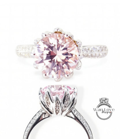 A close-up of a beautiful pink diamond ring with a large central diamond surrounded by smaller diamonds on the band.