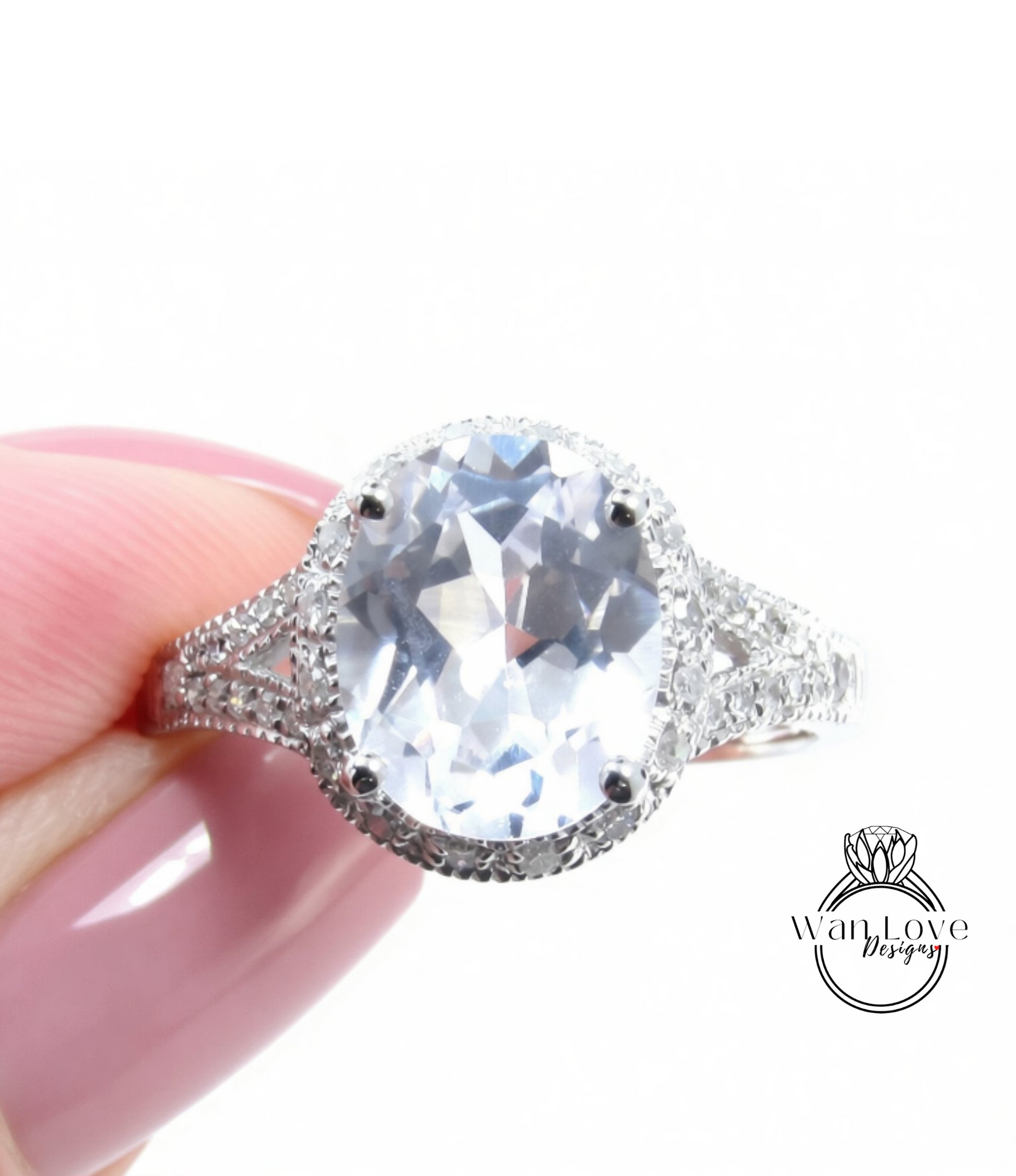 A close-up image of a person's hand holding a large, sparkling diamond ring with a halo of smaller diamonds around the center stone.