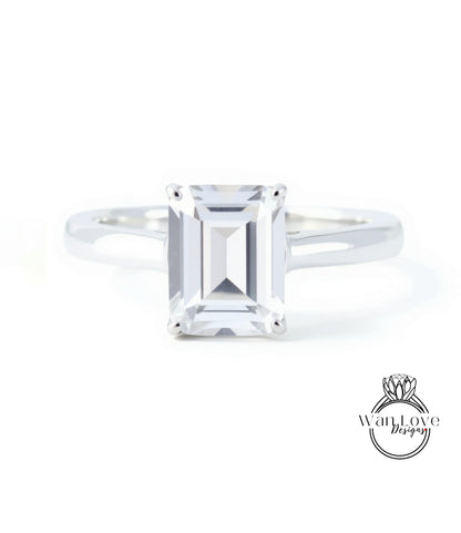 A diamond engagement ring with a large, clear gemstone set in a silver band.