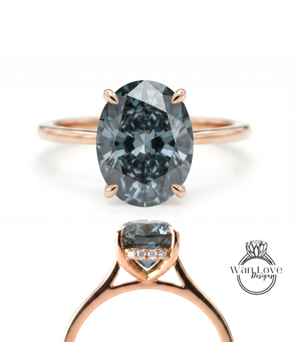 a rose gold ring with a large oval-shaped blue diamond as the centerpiece.