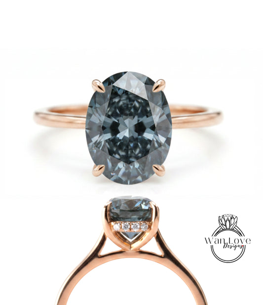 a rose gold ring with a large oval-shaped blue diamond as the centerpiece.