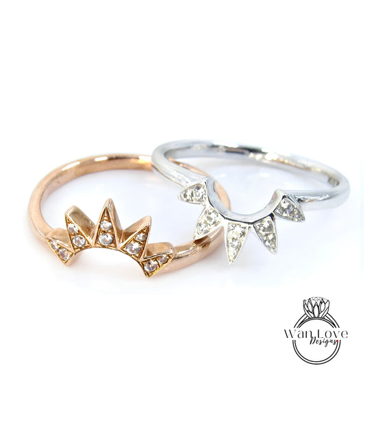 Two rings with different designs, one with a sunburst pattern and the other with a floral design, are displayed against a white background.