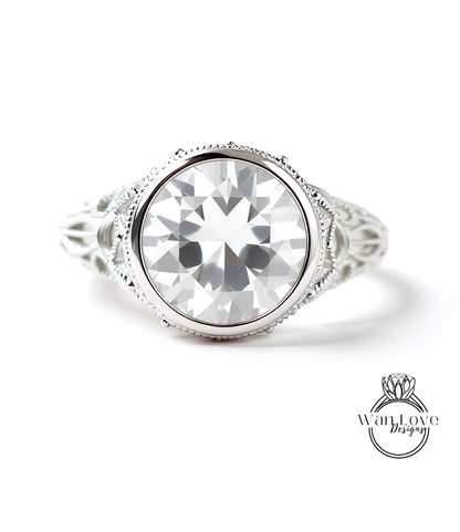 A close-up of a large, clear gemstone set in an ornate, silver-toned ring.