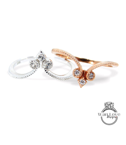 two rings with diamond-encrusted designs, one silver and one gold, against a white background.