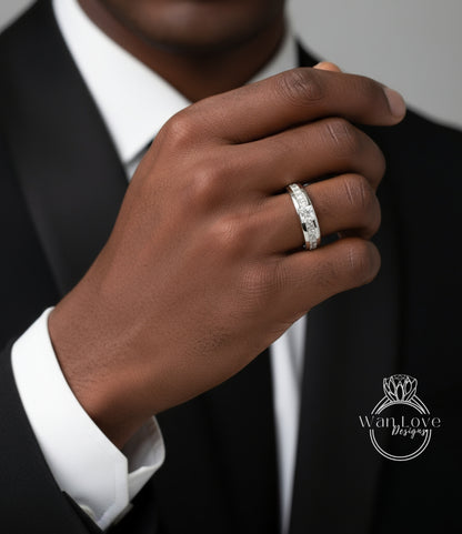 A close-up of a person's hand wearing a diamond ring, with a black suit jacket visible.