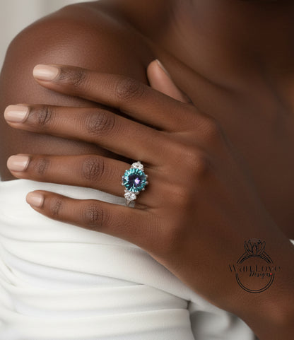 A close-up of a person's hand wearing a ring with a blue gemstone, resting on a white fabric.