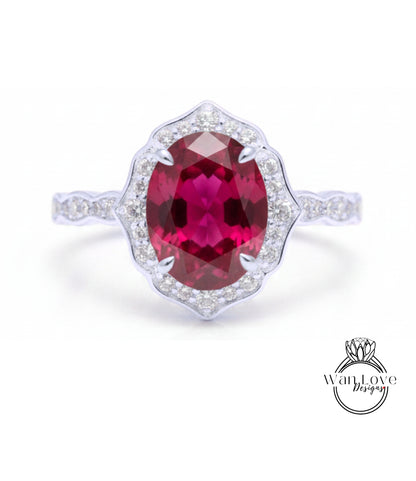A stunning ring featuring a large oval-shaped red gemstone surrounded by a halo of smaller diamonds set in a silver band.