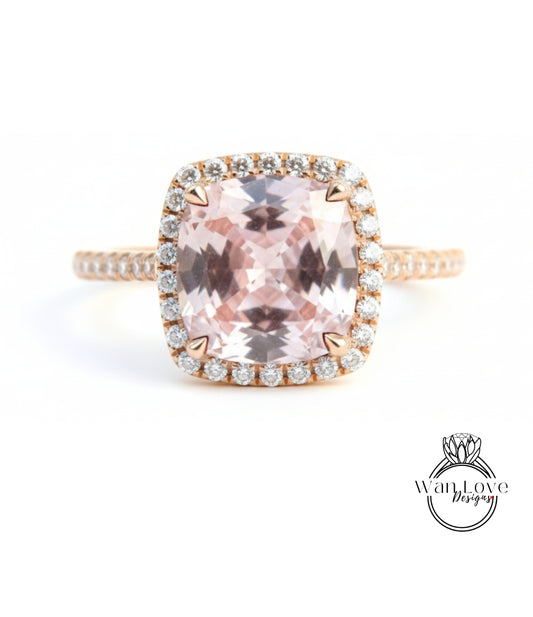 A beautiful engagement ring with a large, pink gemstone set in a halo of smaller diamonds.