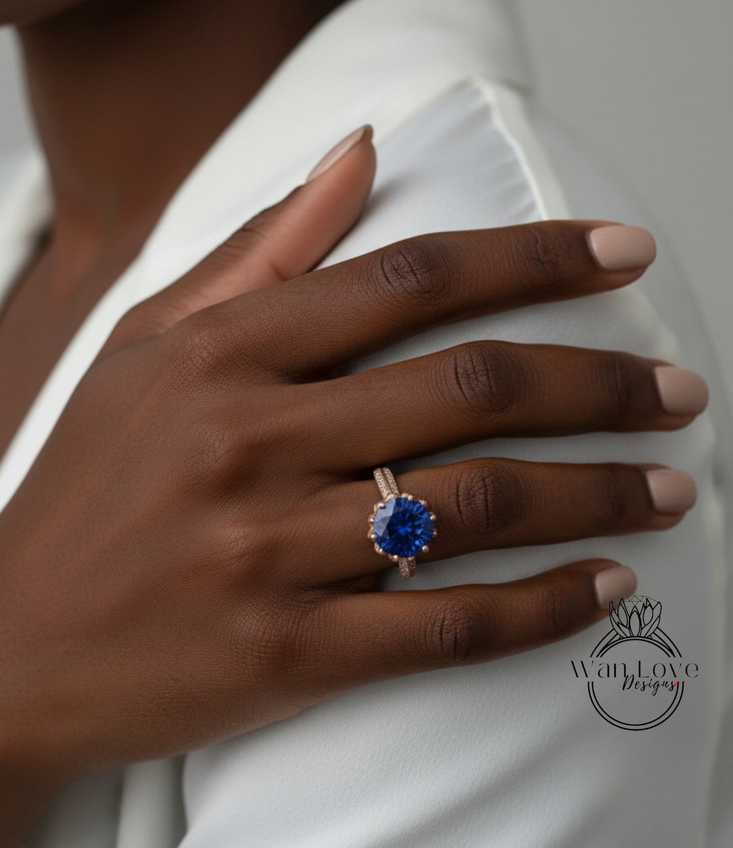 A close-up of a person's hand wearing a ring with a large blue gemstone.