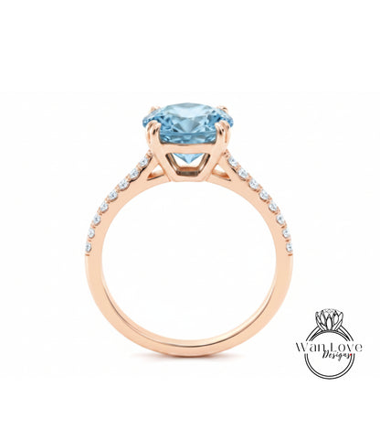 A gold ring with a large blue gemstone, likely a diamond, set in the center.