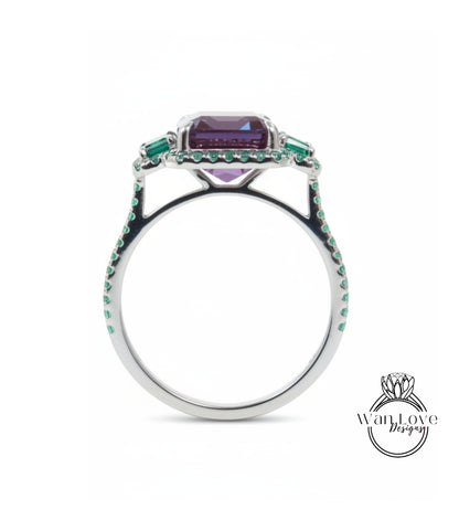 A silver ring with a large purple gemstone and green gemstones set in the center.