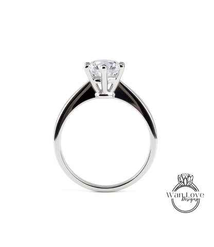 A silver engagement ring with a large central diamond and a smaller diamond on the band.