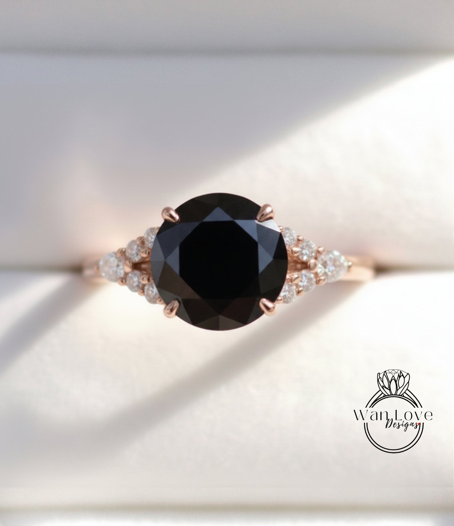 A close-up image of a gold ring with a large black diamond as the centerpiece, surrounded by smaller diamonds.