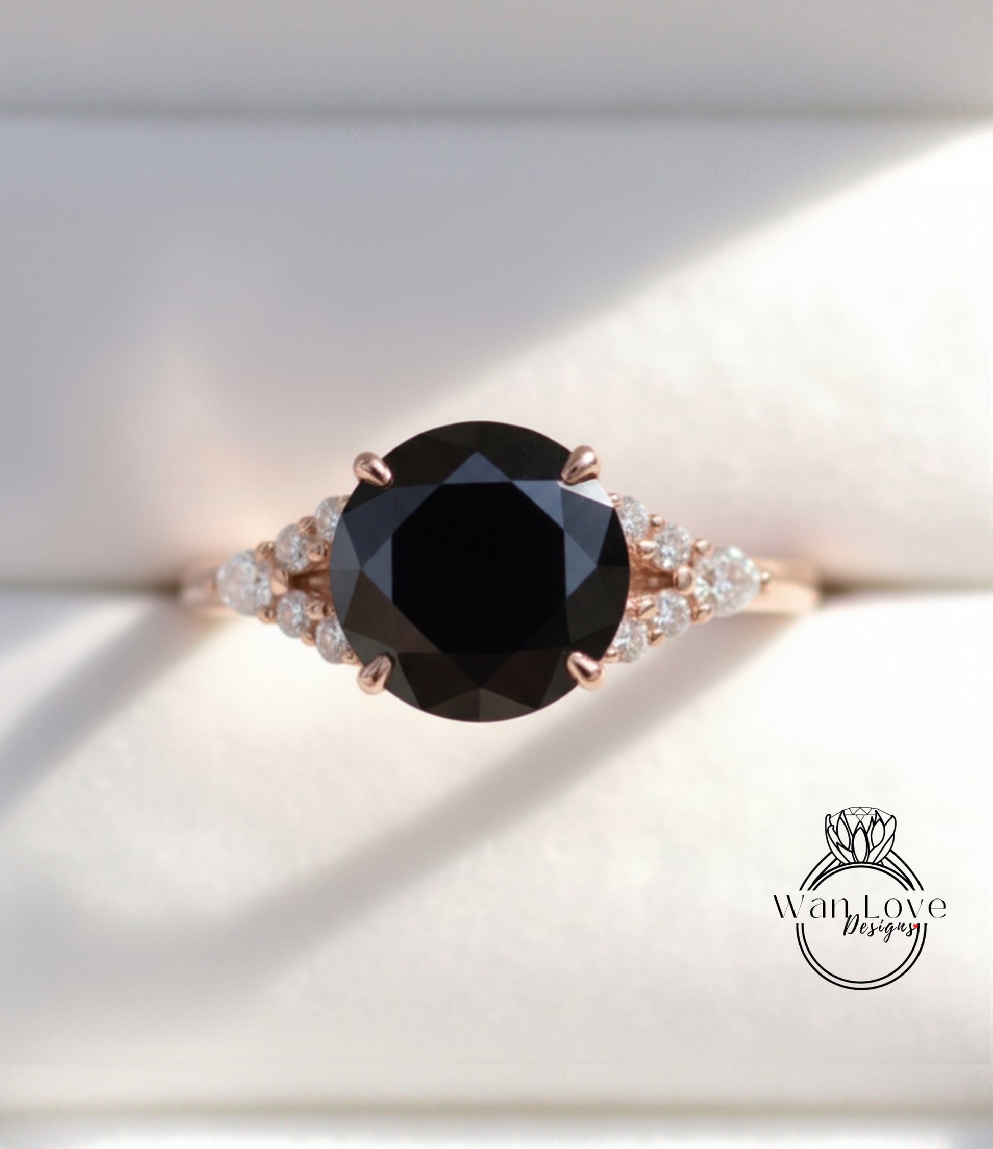 A close-up image of a gold ring with a large black diamond as the centerpiece, surrounded by smaller diamonds.