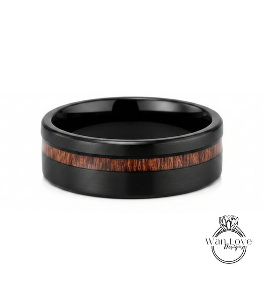 A black ring with a wooden band in the center, showcasing a natural wood grain pattern.