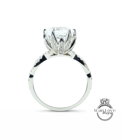 A silver engagement ring with a large, round diamond set in the center, surrounded by smaller diamonds.