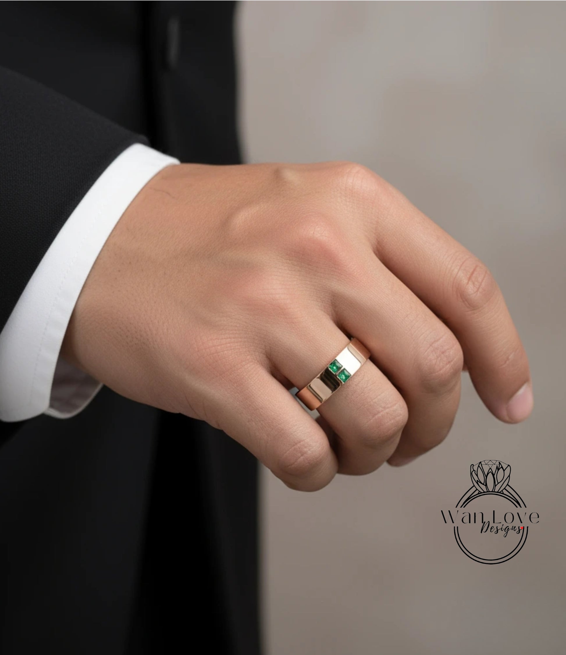 A close-up of a person's hand wearing a gold ring with a green gemstone.