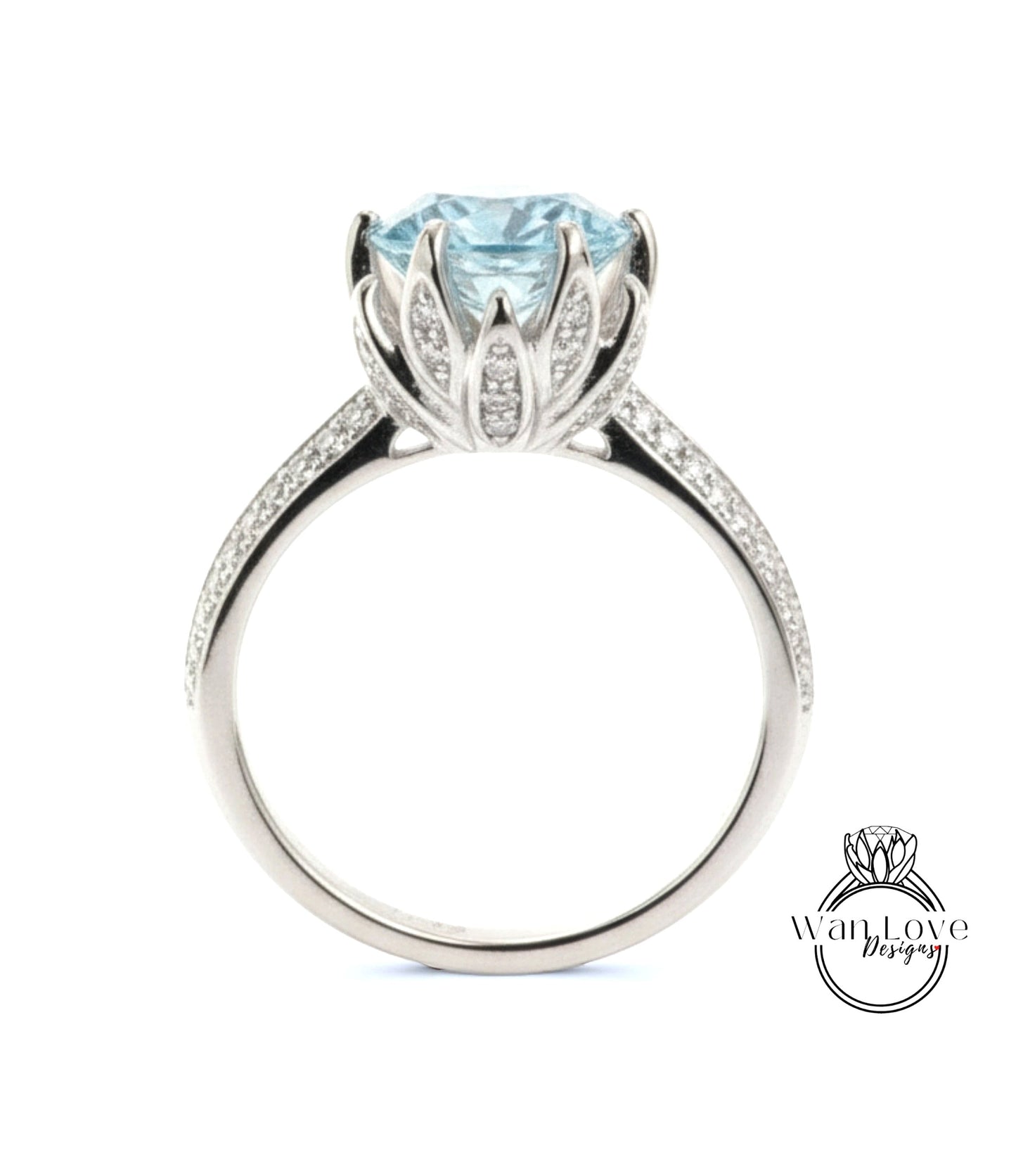 A silver ring with a large blue gemstone, likely a diamond, set in a decorative flower-like design.