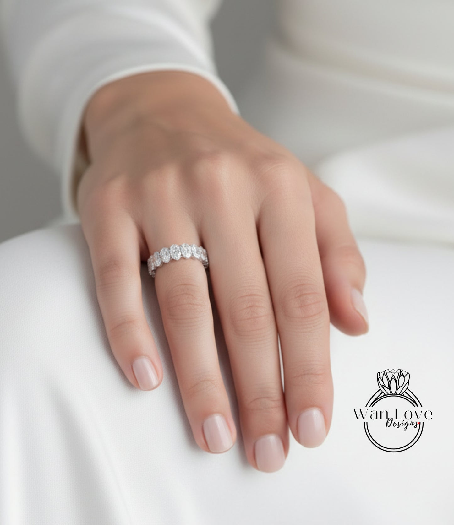 A close-up of a hand wearing a diamond ring on the ring finger.