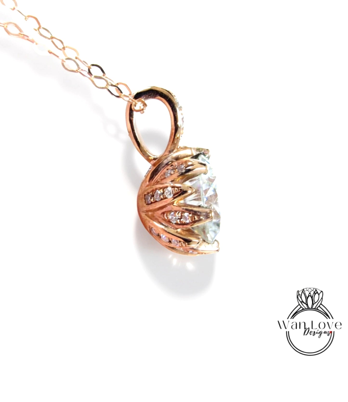 A close-up view of a delicate gold-toned pendant necklace with a large, clear gemstone set in a floral-designed metal piece.