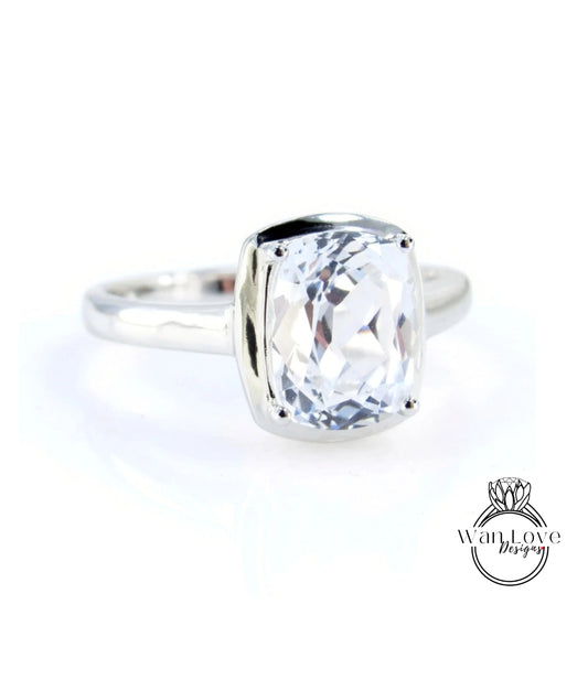 A silver ring with a large, clear gemstone set in the center.