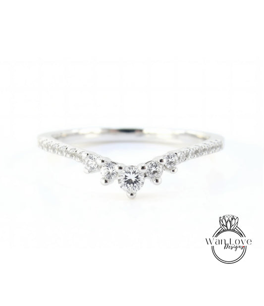 A silver ring with a large central diamond surrounded by smaller diamonds, set in a band.