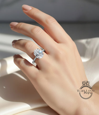 A close-up of a hand wearing a diamond engagement ring, with the ring's diamond visible.
