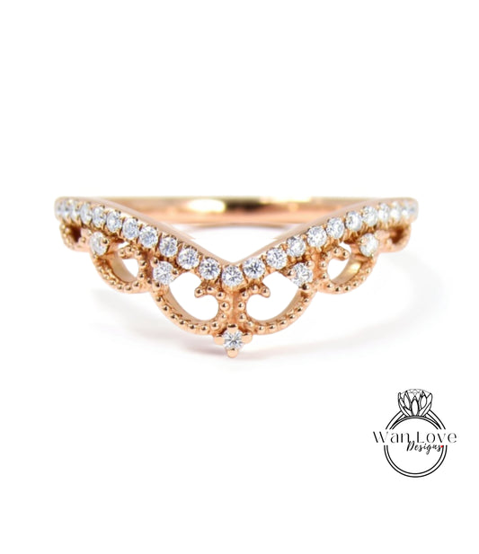 A rose gold ring with a decorative band featuring a floral design and small diamonds.