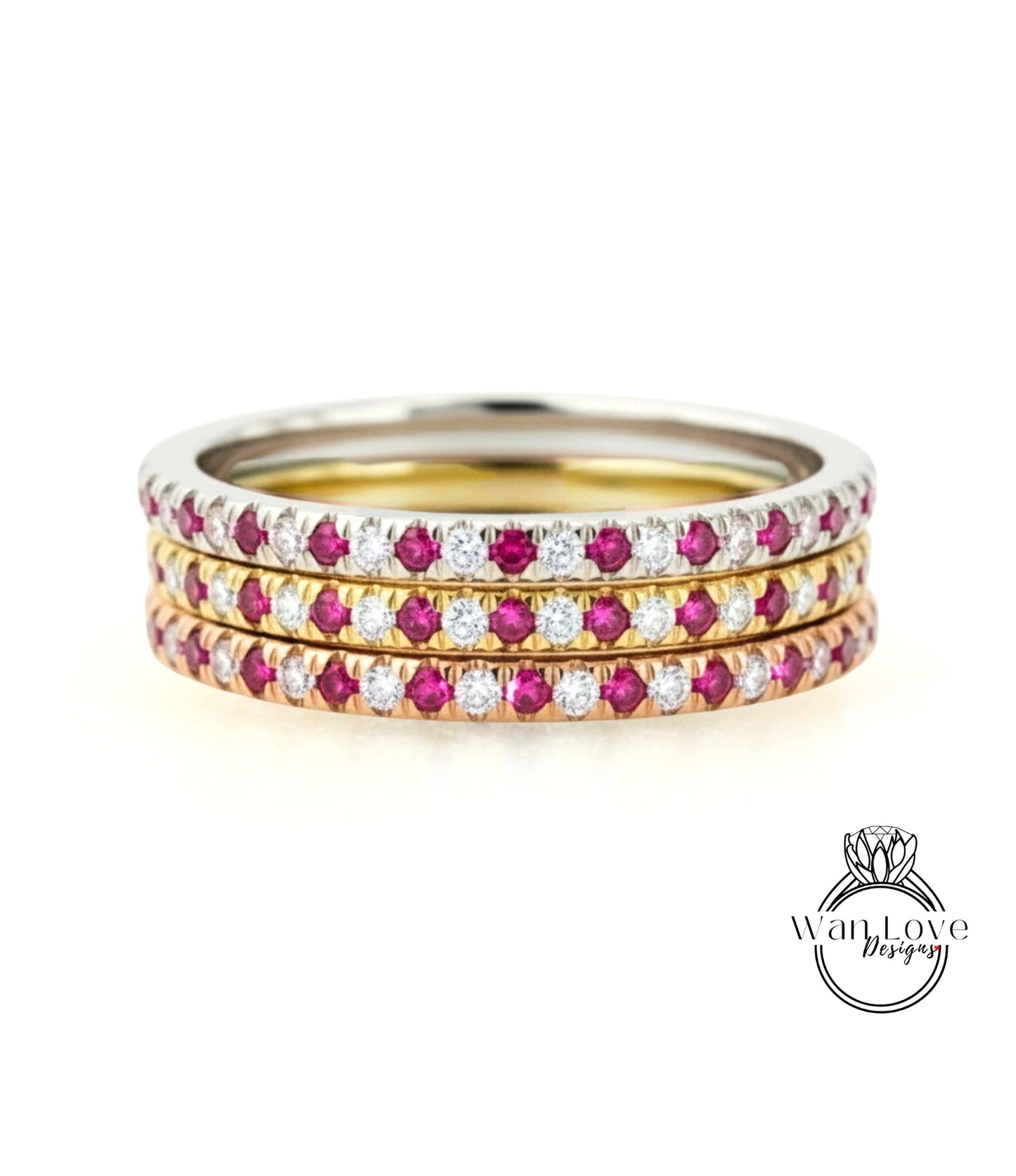 A stack of three rings with a metallic band and a row of red and white gemstones.