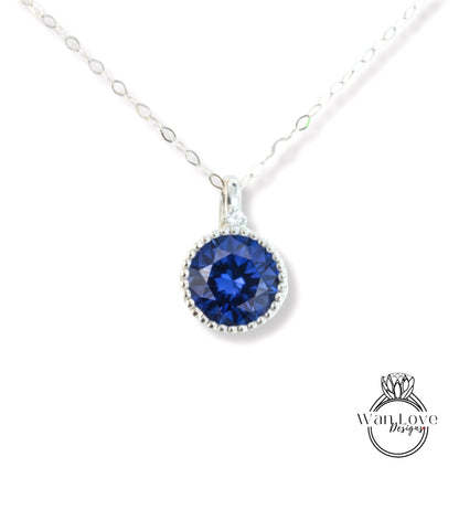 A silver necklace with a large blue gemstone pendant.