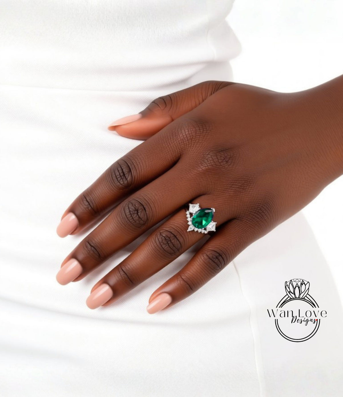 A close-up of a hand wearing a ring with a large green gemstone.