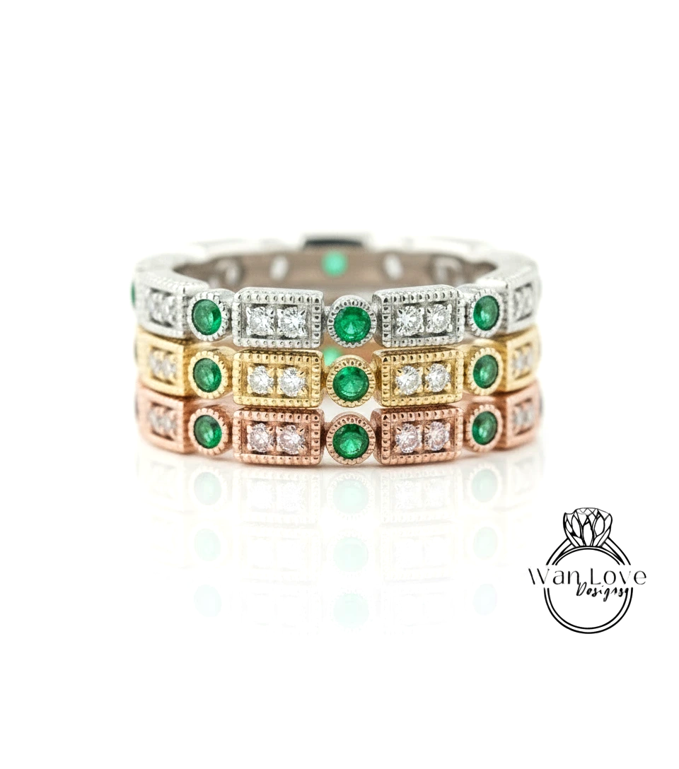 A ring with multiple layers of rings, each ring adorned with a green gemstone and a diamond.