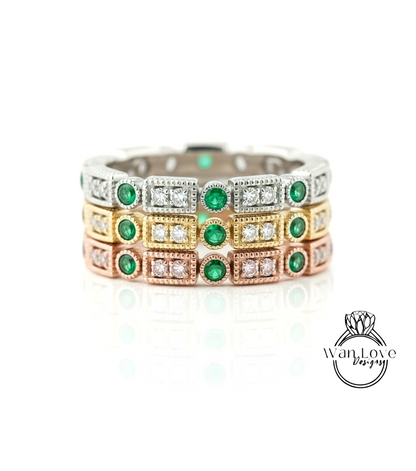 A ring with multiple layers of rings, each ring adorned with a green gemstone and a diamond.