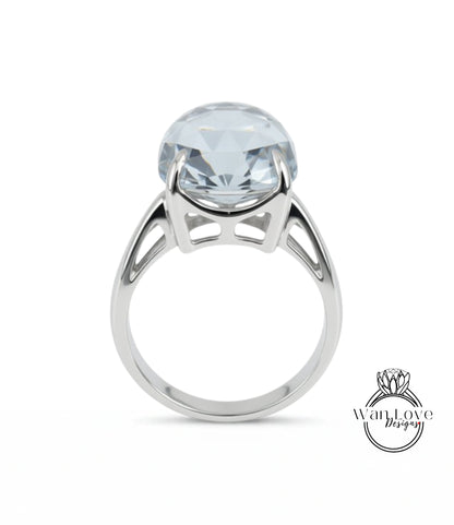A silver ring with a large, clear gemstone set in the center.