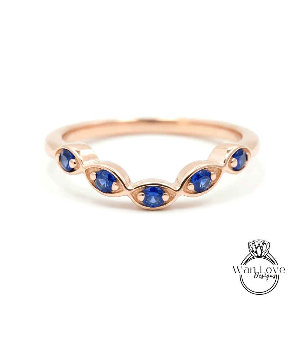 A rose gold ring with a row of blue sapphire gemstones set in the center.